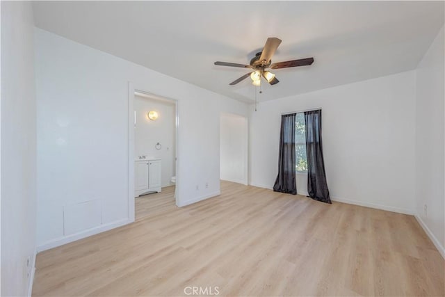 spare room with light wood-style floors, baseboards, and ceiling fan