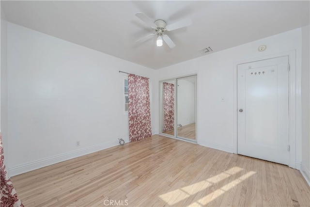 unfurnished bedroom with a closet, visible vents, light wood-style flooring, and baseboards