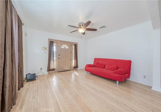 living area with a ceiling fan, baseboards, visible vents, and light wood-type flooring