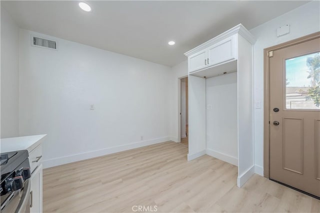 interior space featuring visible vents, light wood-type flooring, and baseboards