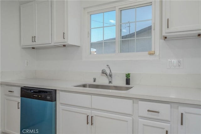 kitchen with dishwashing machine, white cabinets, light countertops, and a sink