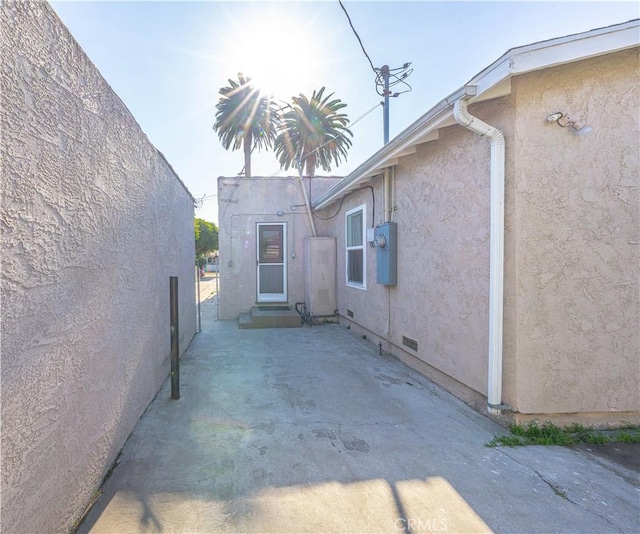 view of property exterior with crawl space, a patio area, and stucco siding