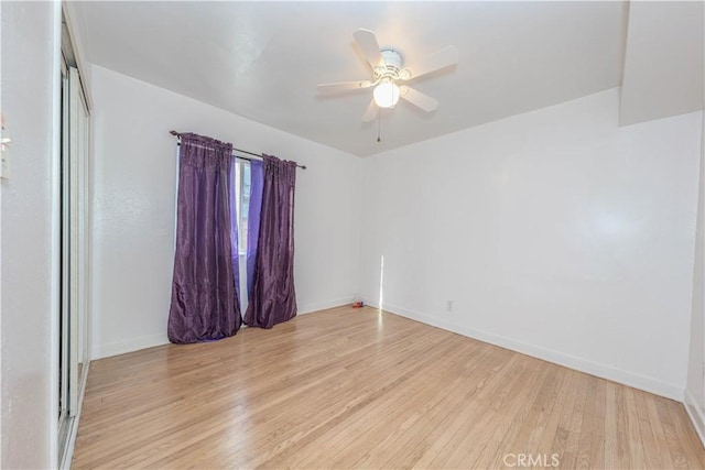 unfurnished room with baseboards, ceiling fan, and light wood finished floors