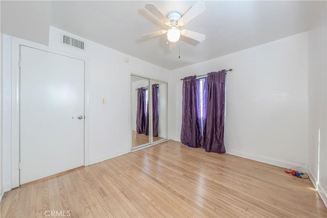 unfurnished bedroom featuring visible vents, light wood-style flooring, a closet, baseboards, and ceiling fan