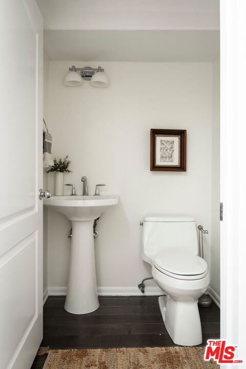 bathroom with hardwood / wood-style flooring and toilet