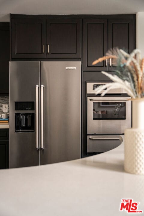 kitchen featuring dark brown cabinets and stainless steel refrigerator with ice dispenser