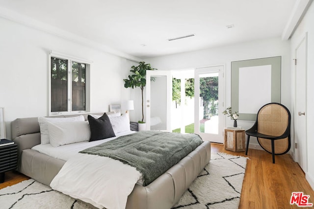 bedroom with access to outside and light hardwood / wood-style floors