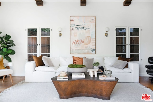 living room with hardwood / wood-style floors, beamed ceiling, and french doors