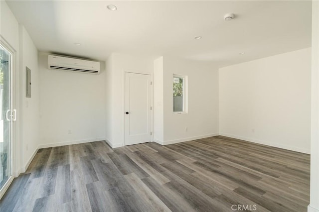 empty room with hardwood / wood-style floors and a wall mounted AC