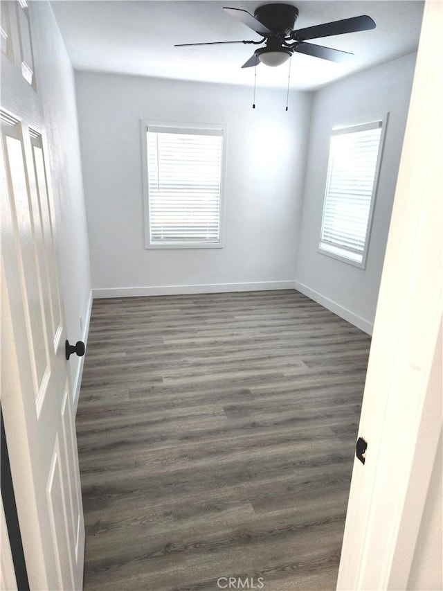 unfurnished room with ceiling fan and dark hardwood / wood-style flooring