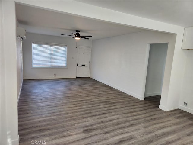 unfurnished room with dark hardwood / wood-style flooring, an AC wall unit, and ceiling fan