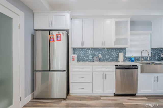 kitchen featuring tasteful backsplash, sink, white cabinets, and appliances with stainless steel finishes