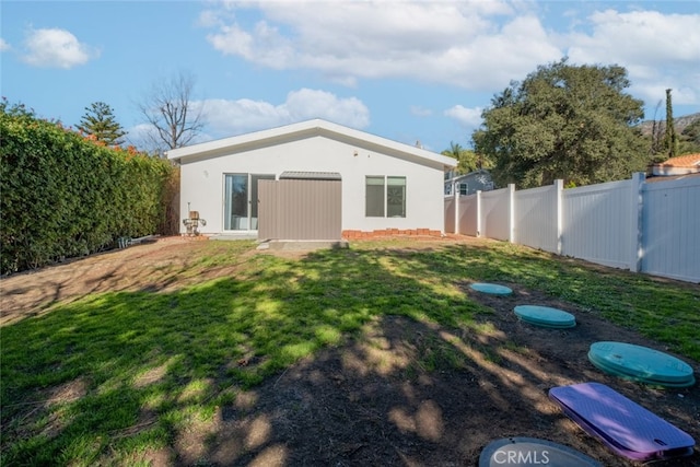 back of house featuring a lawn