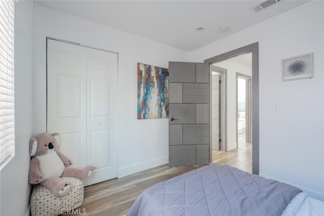 bedroom with light hardwood / wood-style floors and a closet