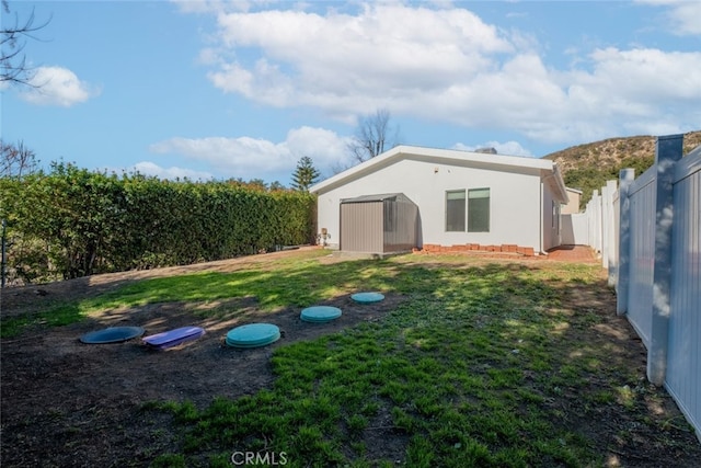 rear view of house featuring a lawn and a shed