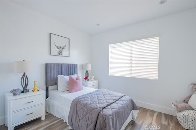 bedroom with multiple windows and light hardwood / wood-style floors