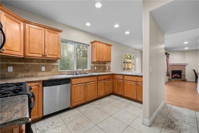 kitchen with decorative backsplash, stainless steel dishwasher, ceiling fan, sink, and light tile patterned floors