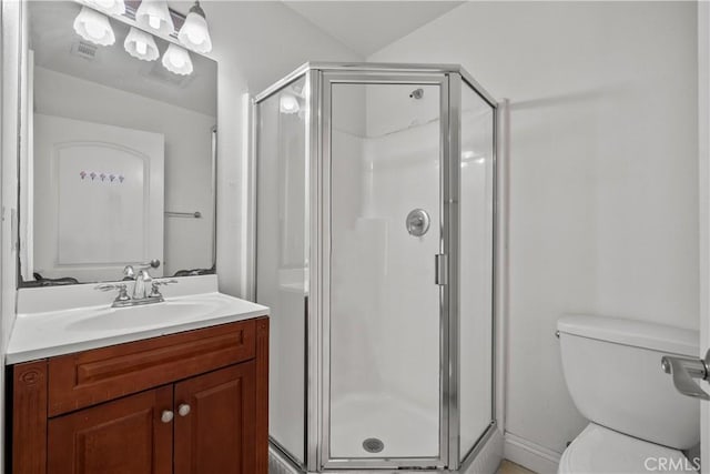 bathroom featuring vanity, a shower with shower door, and toilet