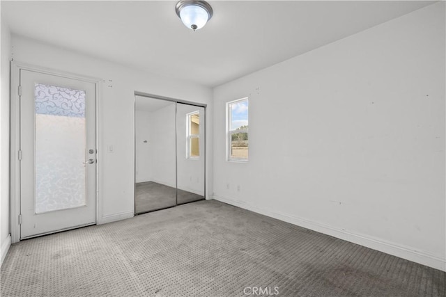 unfurnished bedroom with light colored carpet and a closet