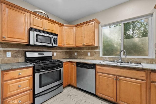 kitchen featuring backsplash, sink, light tile patterned flooring, and stainless steel appliances