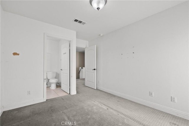 unfurnished bedroom with ensuite bathroom and light colored carpet