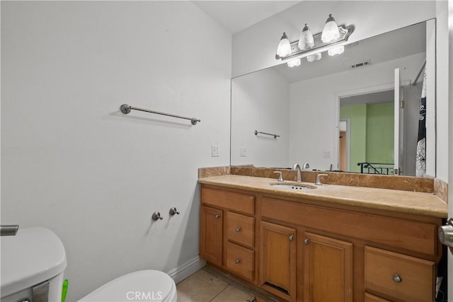 bathroom with tile patterned flooring, vanity, and toilet