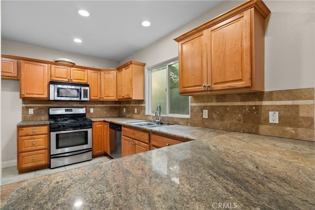 kitchen featuring backsplash, sink, light tile patterned floors, and stainless steel appliances