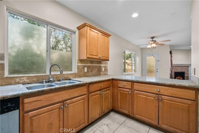 kitchen featuring ceiling fan, sink, tasteful backsplash, stainless steel dishwasher, and kitchen peninsula