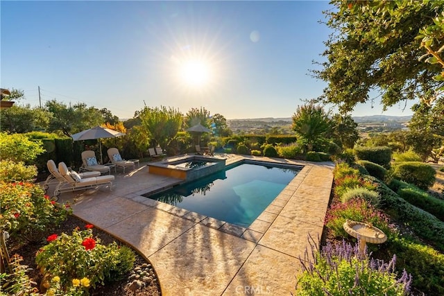 view of swimming pool featuring a patio area and an in ground hot tub