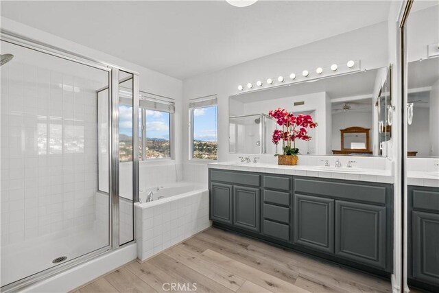 bathroom featuring hardwood / wood-style floors, vanity, and separate shower and tub