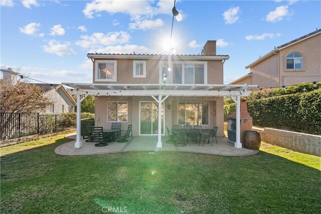 back of house with a pergola, a yard, and a patio