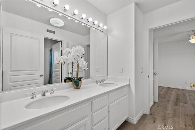 bathroom featuring ceiling fan, hardwood / wood-style floors, and vanity