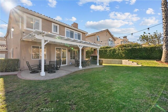 back of property with a patio area, a pergola, a fireplace, and a yard