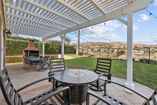 view of patio featuring outdoor dining space, an outdoor fireplace, fence, and a pergola