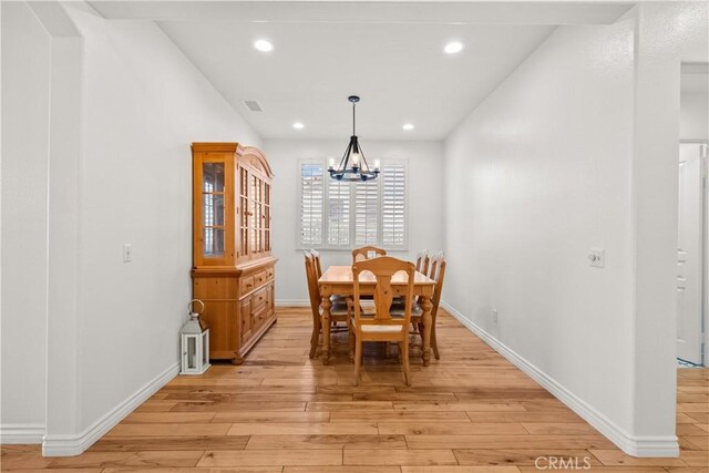 dining space with a chandelier and light hardwood / wood-style floors