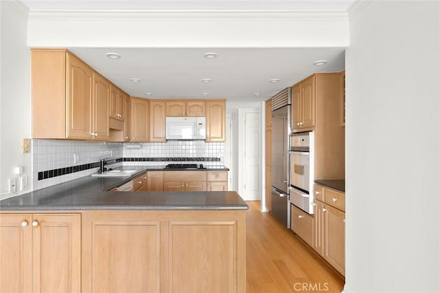 kitchen featuring kitchen peninsula, sink, light brown cabinets, and appliances with stainless steel finishes