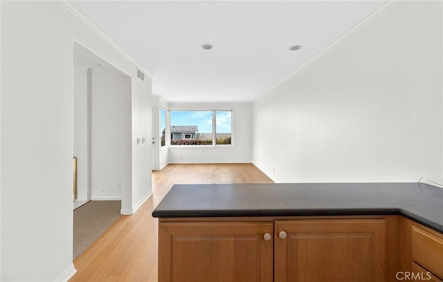 kitchen featuring light hardwood / wood-style floors and crown molding