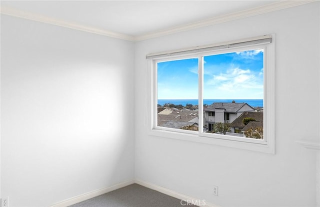 carpeted empty room featuring a water view and ornamental molding