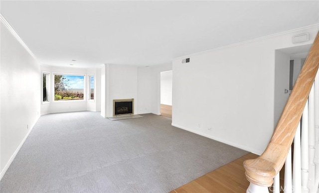 unfurnished living room featuring hardwood / wood-style flooring and crown molding