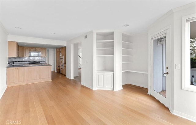 unfurnished living room featuring light hardwood / wood-style flooring and ornamental molding