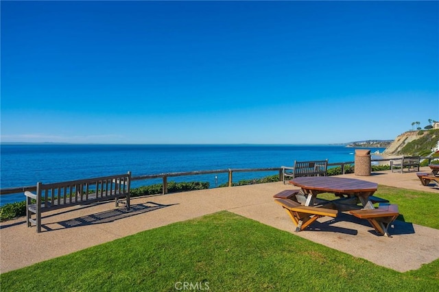 view of property's community featuring a lawn and a water view