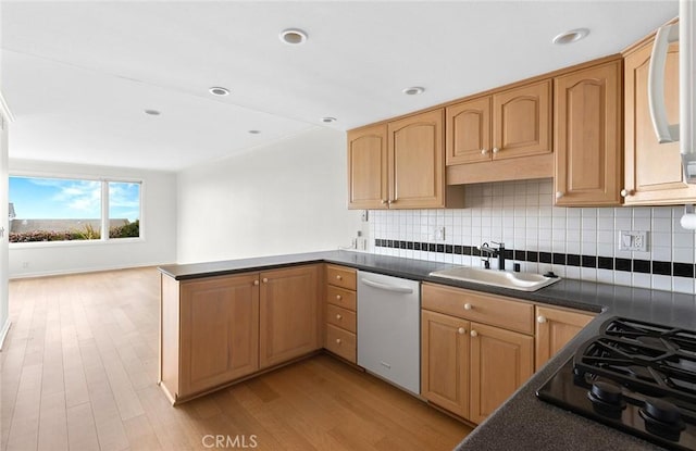 kitchen featuring white dishwasher, black gas stovetop, sink, light hardwood / wood-style flooring, and kitchen peninsula