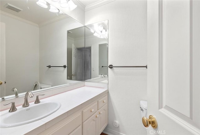 bathroom featuring vanity, toilet, and ornamental molding