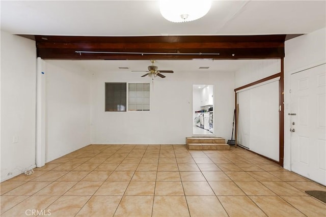 unfurnished room with ceiling fan, beam ceiling, and light tile patterned floors