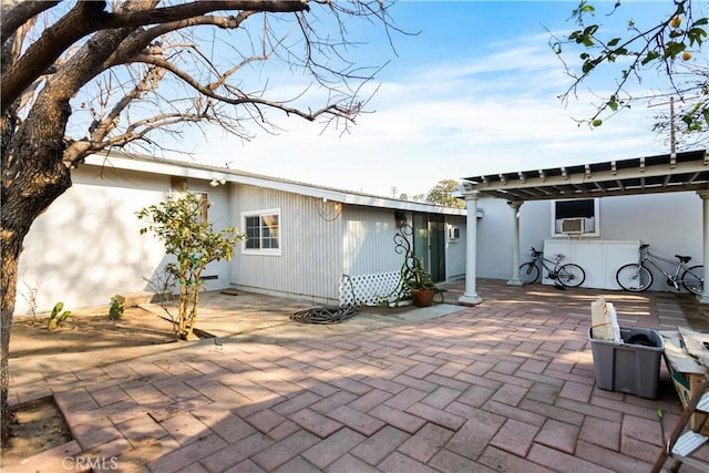 rear view of house featuring a pergola, a patio area, and cooling unit