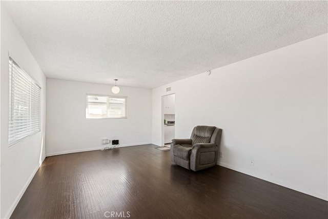 unfurnished room with a textured ceiling and dark hardwood / wood-style flooring