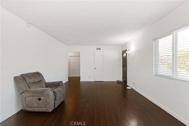 sitting room with dark hardwood / wood-style flooring and a textured ceiling