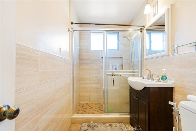 bathroom featuring walk in shower, a wealth of natural light, tile walls, and toilet