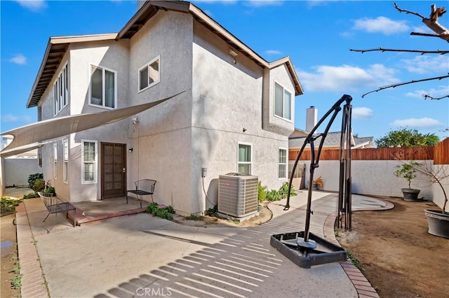 rear view of property with cooling unit and a patio area