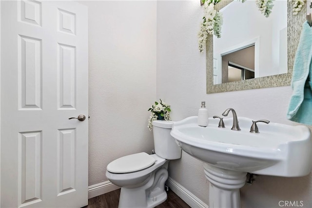 bathroom with hardwood / wood-style floors and toilet